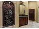 Stylish wine cellar entrance with decorative iron gate and a charming display niche with dark wood cabinets at 9290 E Thompson Peak Pkwy # 409, Scottsdale, AZ 85255