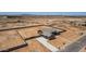 Aerial view of a single-Gathering home with a concrete driveway, expansive yard with block fencing in a desert landscape at 9485 W Sandstone Mountain Dr, Casa Grande, AZ 85194