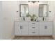 Bathroom featuring a double vanity with framed mirrors, white cabinets, and black hardware at 9485 W Sandstone Mountain Dr, Casa Grande, AZ 85194