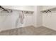 Walk-in closet with neutral carpet, white walls, and wooden rods for hanging clothes at 9485 W Sandstone Mountain Dr, Casa Grande, AZ 85194