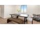 Modern dining room featuring a dark table, a bench, chairs, and natural light from a window at 9485 W Sandstone Mountain Dr, Casa Grande, AZ 85194