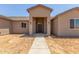 Tan single-story house with covered entrance, new construction with desert landscaping at 9485 W Sandstone Mountain Dr, Casa Grande, AZ 85194