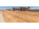 Exterior of tan single-story house and adjacent lot in desert setting with blue sky at 9485 W Sandstone Mountain Dr, Casa Grande, AZ 85194