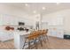 Modern kitchen with white cabinets, quartz countertops, an island with seating, and stainless appliances at 9485 W Sandstone Mountain Dr, Casa Grande, AZ 85194