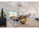 Bright living room with vaulted ceilings, a modern rug, comfortable seating, and seamless kitchen access at 9485 W Sandstone Mountain Dr, Casa Grande, AZ 85194