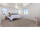 Bright main bedroom features natural light, neutral carpet, a ceiling fan, and light colored walls at 9485 W Sandstone Mountain Dr, Casa Grande, AZ 85194