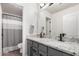 Bathroom with a double sink vanity, granite countertop, and modern fixtures at 9566 E Plana Ave, Mesa, AZ 85212