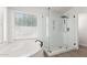 Bright bathroom featuring a separate glass shower enclosure, soaking tub, and a large window at 9566 E Plana Ave, Mesa, AZ 85212