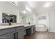 Modern bathroom featuring double vanity, granite countertops, separate shower, and soaking tub at 9566 E Plana Ave, Mesa, AZ 85212
