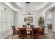 Elegant dining room featuring a tray ceiling, wainscoting, shuttered windows, and wood flooring at 9566 E Plana Ave, Mesa, AZ 85212