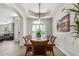 Elegant dining room featuring a tray ceiling, wainscoting, shuttered windows, and wood flooring at 9566 E Plana Ave, Mesa, AZ 85212