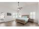 Bright main bedroom features shutters, wood-look floors, access to backyard, and a ceiling fan at 9566 E Plana Ave, Mesa, AZ 85212