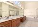 Bathroom boasts a double sink vanity, large mirrors, tiled flooring, and a separate tub and shower at 9802 W Rockwood Dr, Peoria, AZ 85382