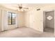 Bright bedroom featuring a window, plush carpet, ceiling fan, and closet space at 9802 W Rockwood Dr, Peoria, AZ 85382