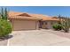 Tan single-story home with desert landscaping and concrete driveway leading to a two car garage at 9802 W Rockwood Dr, Peoria, AZ 85382