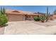 Tan single-story home with desert landscaping and concrete driveway leading to a two car garage at 9802 W Rockwood Dr, Peoria, AZ 85382