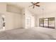 Spacious living room featuring high ceilings, neutral carpet, and a sliding glass door to the patio at 9802 W Rockwood Dr, Peoria, AZ 85382