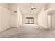Spacious living room featuring high ceilings, neutral carpet, and a sliding glass door to the patio at 9802 W Rockwood Dr, Peoria, AZ 85382