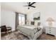 Bright bedroom featuring a ceiling fan, wood floors, and a large window for natural light at 10080 E Mountainview Lake Dr # 327, Scottsdale, AZ 85258