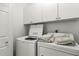 Bright laundry room boasts white washer and dryer with white storage cabinets at 10080 E Mountainview Lake Dr # 327, Scottsdale, AZ 85258