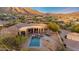 Aerial view of a luxury home with a pool, spa, outdoor kitchen, and mountain views at 11986 N 134Th Pl, Scottsdale, AZ 85259