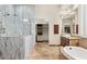 Elegant bathroom featuring a marble shower, soaking tub, and walk-in closet at 11986 N 134Th Pl, Scottsdale, AZ 85259