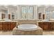 Luxurious bathroom features a soaking tub, dual sinks, and a large window with shutters at 11986 N 134Th Pl, Scottsdale, AZ 85259