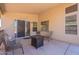 Covered back patio with neutral colored concrete, sliding glass door, windows, and outdoor seating at 12208 N 41St Ln, Phoenix, AZ 85029