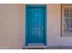 Close-up of a stylish blue front door with decorative panels and modern hardware at 12208 N 41St Ln, Phoenix, AZ 85029