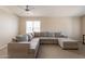 Spacious living room with a large sectional couch, ceiling fan, and bright natural light at 12208 N 41St Ln, Phoenix, AZ 85029