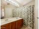 Full bathroom featuring double sinks, large mirror, and shower with curtain at 12208 N 41St Ln, Phoenix, AZ 85029