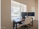 Functional home office setup with dual monitors, a laptop, and comfortable seating by the window at 12208 N 41St Ln, Phoenix, AZ 85029