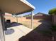 Large backyard featuring a covered patio, brick walls, and potential for landscaping at 12934 W Voltaire Ave, El Mirage, AZ 85335