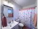 Bright bathroom featuring vanity sink and shower-tub combo with decorative floral shower curtain at 12934 W Voltaire Ave, El Mirage, AZ 85335