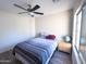 This room features a ceiling fan, a window, and a single bed and end table at 12934 W Voltaire Ave, El Mirage, AZ 85335