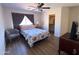 This bedroom has wood floors, a ceiling fan, and a walk-in closet at 12934 W Voltaire Ave, El Mirage, AZ 85335