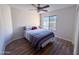 Bright bedroom with light wood flooring features a ceiling fan and a view from the window at 12934 W Voltaire Ave, El Mirage, AZ 85335