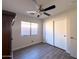 Neutral bedroom with a ceiling fan, closet, and a view from the window at 12934 W Voltaire Ave, El Mirage, AZ 85335