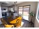 Cozy dining area showcasing wood table and chairs adjacent to a kitchen with white cabinets and backyard patio access at 12934 W Voltaire Ave, El Mirage, AZ 85335