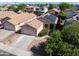 Charming single-story home featuring desert landscaping, a two-car garage, and solar panels for energy efficiency at 12934 W Voltaire Ave, El Mirage, AZ 85335