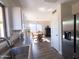 Open kitchen showcasing stainless steel refrigerator, white cabinets, and dining area, creating a functional space at 12934 W Voltaire Ave, El Mirage, AZ 85335