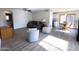 Bright living room with wood-look floors, comfortable seating, and a view into the dining area and kitchen at 12934 W Voltaire Ave, El Mirage, AZ 85335