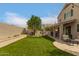 Spacious backyard boasting lush green grass, a charming playhouse, and a covered patio perfect for outdoor gatherings at 13993 N 102Nd St, Scottsdale, AZ 85260