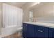 Bathroom with blue vanity, a marble countertop, gold fixtures, and a shower-tub combo at 13993 N 102Nd St, Scottsdale, AZ 85260