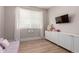 Cozy bedroom featuring wood floors, a TV, and white storage cabinets for a serene and organized space at 13993 N 102Nd St, Scottsdale, AZ 85260