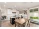 Open kitchen featuring an island, stainless steel appliances, white cabinets, and dining area with backyard views at 13993 N 102Nd St, Scottsdale, AZ 85260