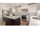 Modern kitchen featuring an island, white cabinets, stainless steel appliances, and wood accents at 13993 N 102Nd St, Scottsdale, AZ 85260