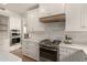 Well-appointed kitchen with stainless steel appliances, gas range, white cabinetry, and stylish backsplash at 13993 N 102Nd St, Scottsdale, AZ 85260