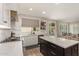 Bright kitchen with white cabinets, an island, open shelving, and backyard views at 13993 N 102Nd St, Scottsdale, AZ 85260