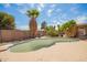 An empty in-ground pool, surrounded by tropical trees and patio, awaiting renovation and landscaping in the backyard at 1407 W Utopia Rd, Phoenix, AZ 85027